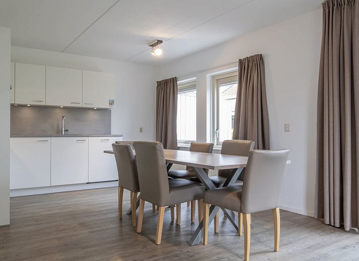 Lichte en ruime eetkamer van SD6 Comfort bungalow in Renesse, Schouwen-Duiveland, Zeeland met uitzicht op de tuin.