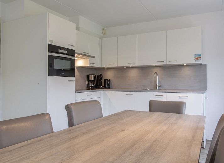 Lichte en ruime eetkamer van SD6 Comfort bungalow in Renesse, Schouwen-Duiveland, Zeeland met uitzicht op de tuin.