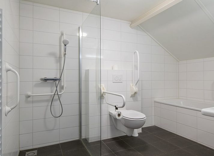 Dining area in SGM Comfort bungalow, Renesse, Zeeland, with modern kitchen and lots of natural light.
