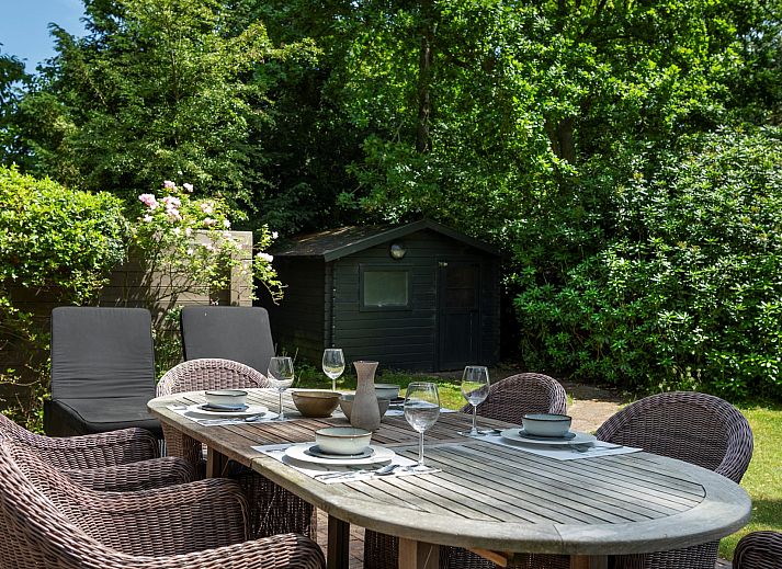 Seitenansicht von Lodge to Lounge, einem Chalet in Nieuw-Haamstede, mit einer sonnigen Terrasse und einem Garten.