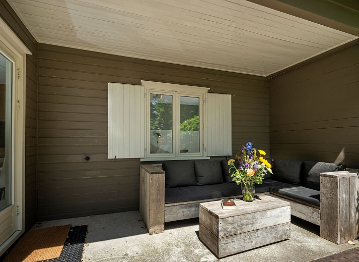 Terrasse des Ferienhauses Populierenlaan 21, Lodge to Lounge, mit bequemen Sitzgelegenheiten in der Natur von Zeeland.