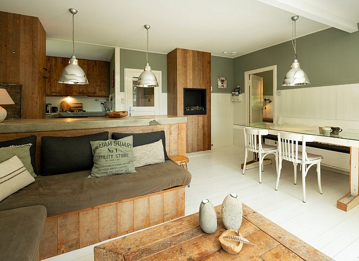 Blick von der Terrasse der Lodge to Lounge in Nieuw-Haamstede, mit Liegestuehlen und gruener Landschaft.