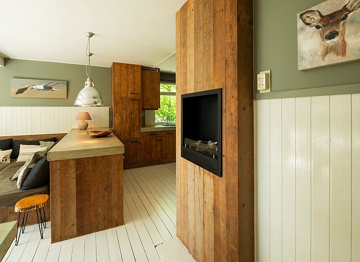 Sonnenliegen auf der Terrasse der Lodge to Lounge in Nieuw-Haamstede, umgeben von bluehenden Pflanzen.