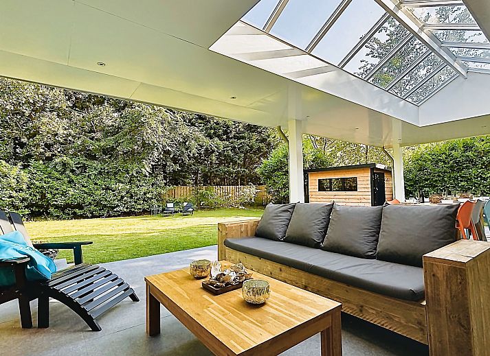 Familienhaus Populierenlaan 5 in Nieuw-Haamstede, ein Ferienhaus mit grosser Veranda und gruenem Garten.