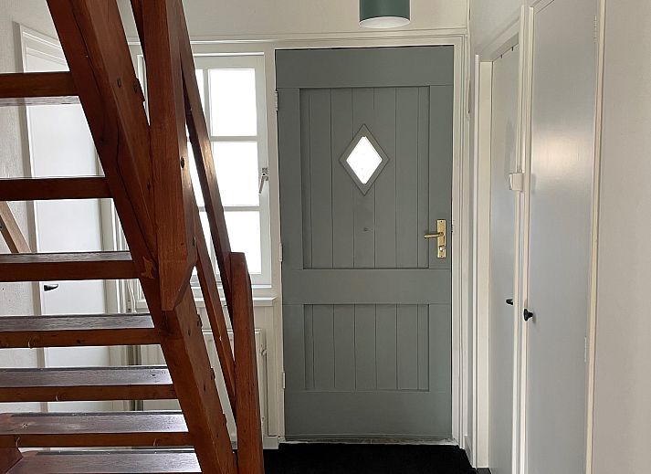 Terras van Vakantiehuis Populierenlaan 3 in Nieuw-Haamstede, Zeeland met tuinmeubilair en parasol.