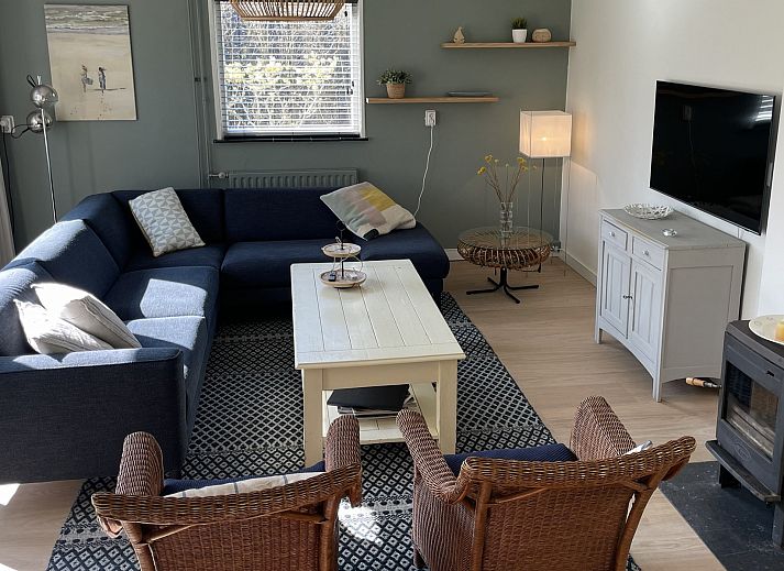 Terras van Vakantiehuis Populierenlaan 3 in Nieuw-Haamstede, Zeeland met tuinmeubilair en parasol.