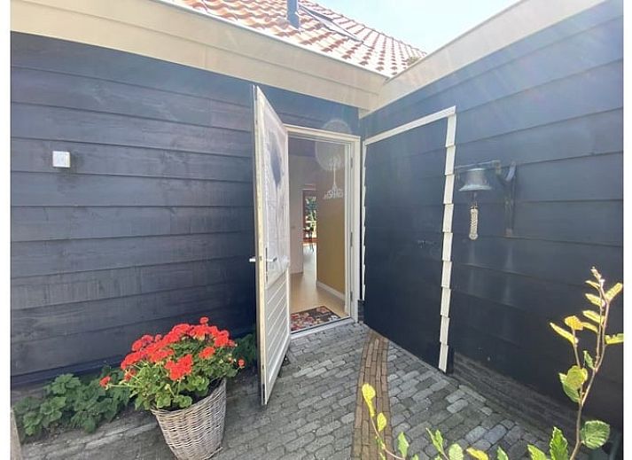 Eingang zum Ferienhaus in Dreischor, einem charmanten Ferienhaus in Schouwen-Duiveland, Zeeland, mit bunten Blumen vor der Tuer.