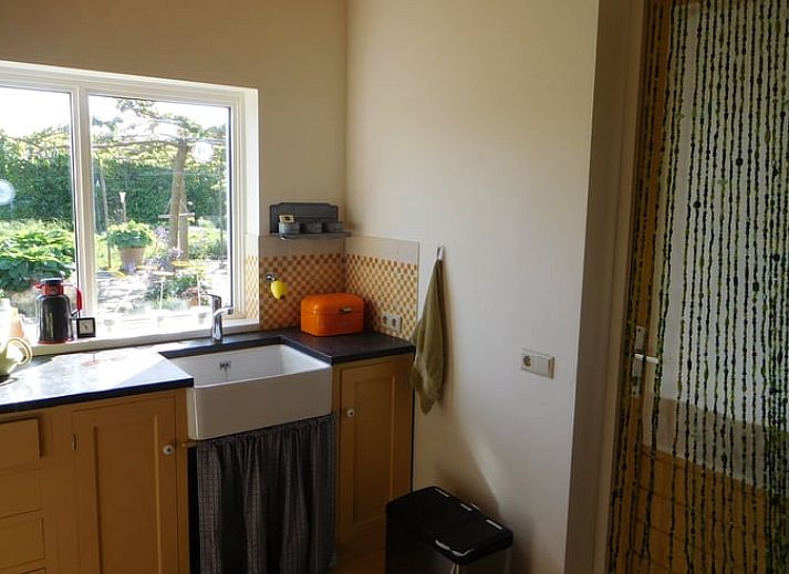 Blick aus dem Fenster des Ferienhauses in Dreischor, einem Ferienhaus in Schouwen-Duiveland, Zeeland, mit einem gruenen Garten und einem Teich.