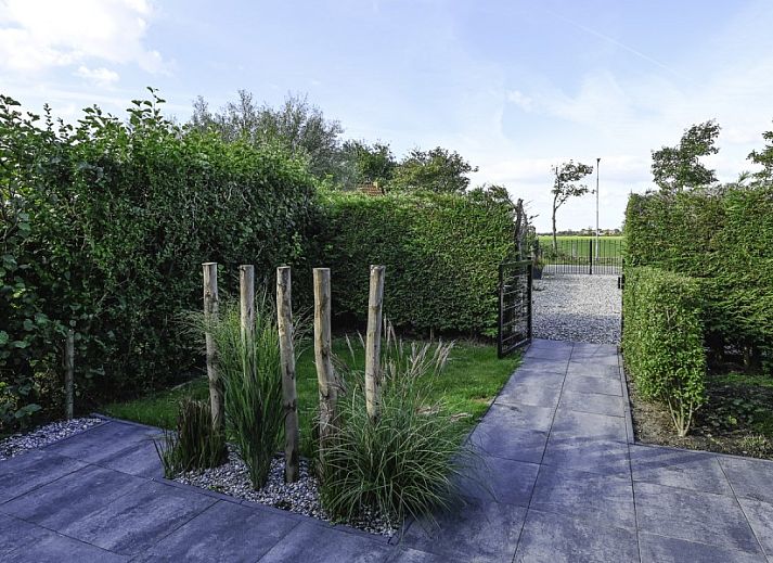 Sonnige Terrasse von Ellemeet am Meer, einem Ferienhaus in Ellemeet, Zeeland, mit bequemen Sitzgelegenheiten im Freien.
