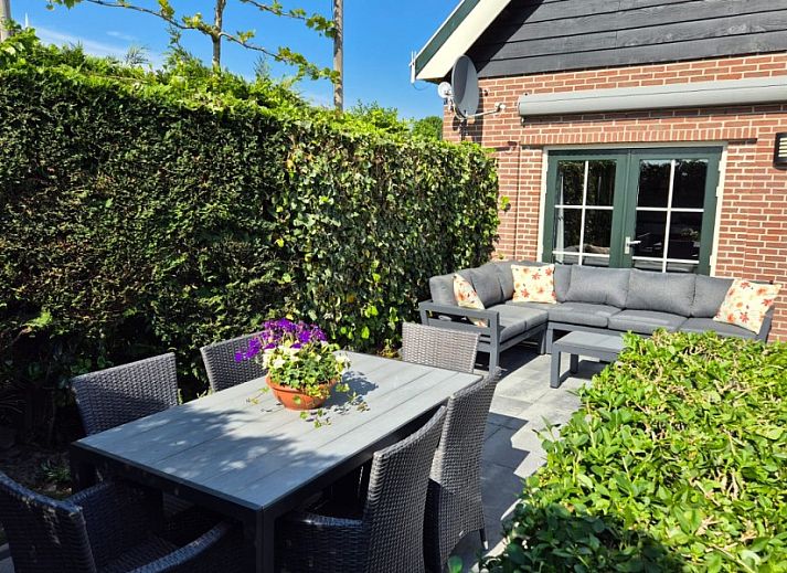 Sonnige Terrasse von Ellemeet am Meer, einem Ferienhaus in Ellemeet, Zeeland, mit bequemen Sitzgelegenheiten im Freien.