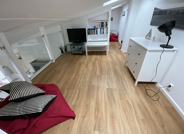 Stylish interior of vacation home Zeelandmuschel in Den Osse, Schouwen-Duiveland, with cozy sitting area and open kitchen.