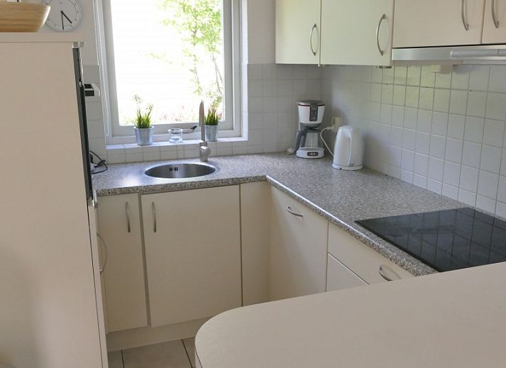 Stylish interior of vacation home Zeelandmuschel in Den Osse, Schouwen-Duiveland, with cozy sitting area and open kitchen.