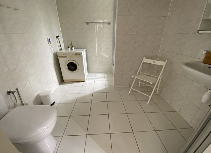 Stylish interior of vacation home Zeelandmuschel in Den Osse, Schouwen-Duiveland, with cozy sitting area and open kitchen.