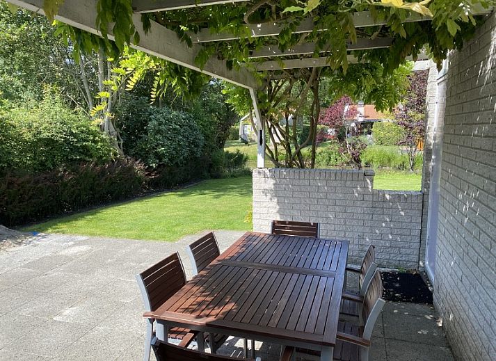 Charming exterior of vacation home Zeelandmuschel in Den Osse, Schouwen-Duiveland, surrounded by green nature and flowers.