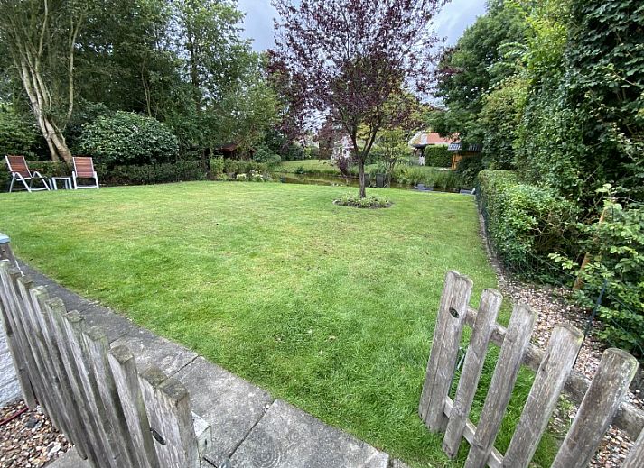 Charming exterior of vacation home Zeelandmuschel in Den Osse, Schouwen-Duiveland, surrounded by green nature and flowers.