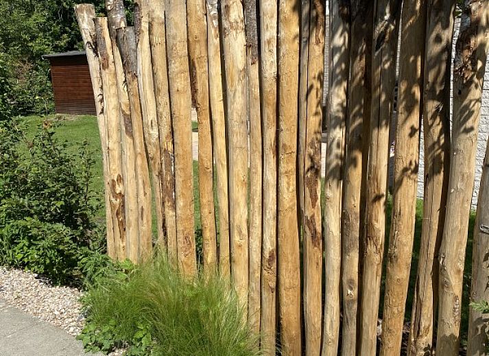 Charming exterior of vacation home Zeelandmuschel in Den Osse, Schouwen-Duiveland, surrounded by green nature and flowers.