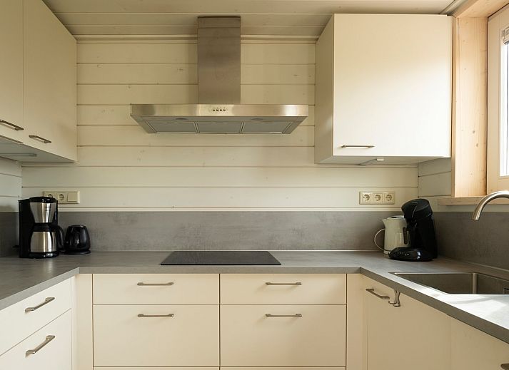 Frontansicht des Ferienhauses Scalde Oort 43 Duinzigt in Westenschouwen, umgeben von viel Gruen in Schouwen-Duiveland, Zeeland.