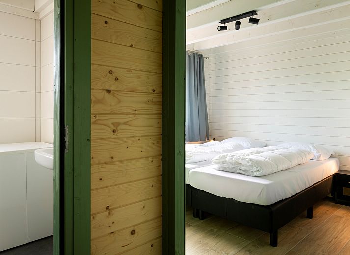 Frontansicht des Ferienhauses Scalde Oort 43 Duinzigt in Westenschouwen, umgeben von viel Gruen in Schouwen-Duiveland, Zeeland.