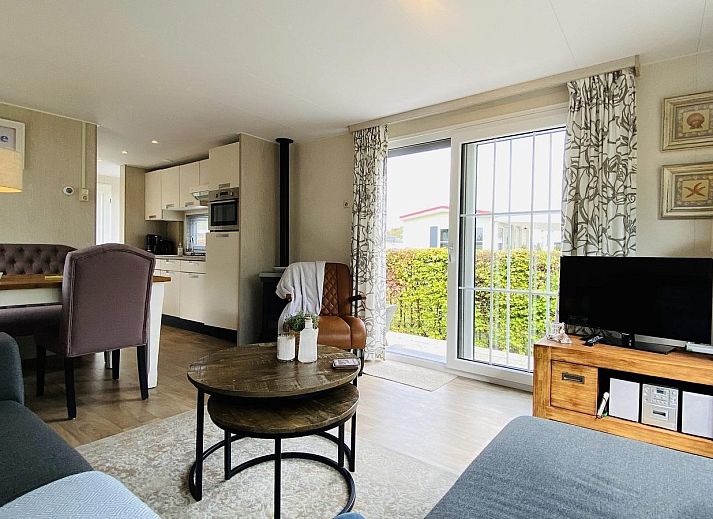 Gemuetliche Terrasse im Ferienhaus VZ539 Ouwerkerk, umgeben von gruenen Hecken in Zeeland.