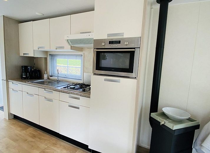 Gemuetliche Terrasse im Ferienhaus VZ539 Ouwerkerk, umgeben von gruenen Hecken in Zeeland.