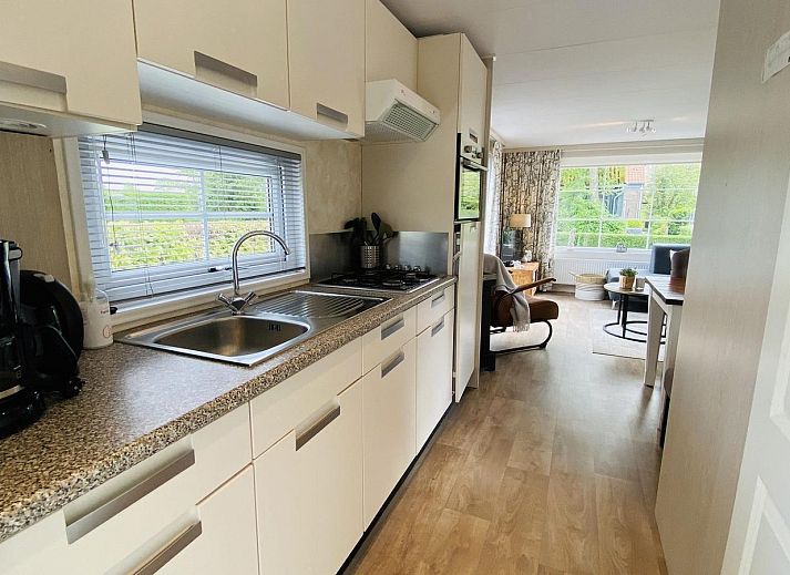 Gemuetliche Terrasse im Ferienhaus VZ539 Ouwerkerk, umgeben von gruenen Hecken in Zeeland.