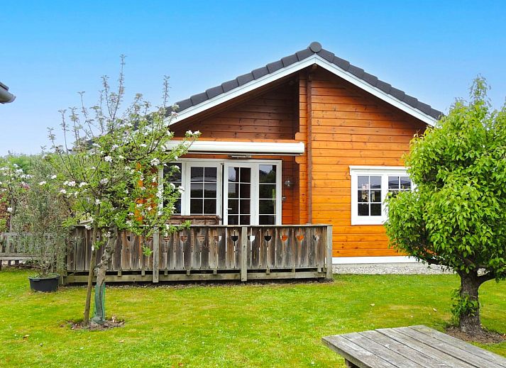 ZeeWolf vakantiehuis in Sint-Annaland, Tholen, Zeeland met houten veranda en groene tuin.