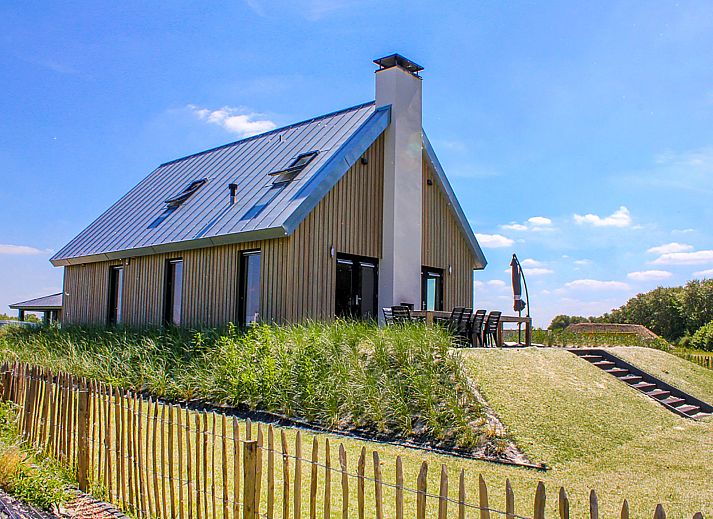 Luchtfoto van Vakantiehuis Oesterdam Resort in Tholen, Zeeland, met prachtig uitzicht op het meer en groene omgeving.