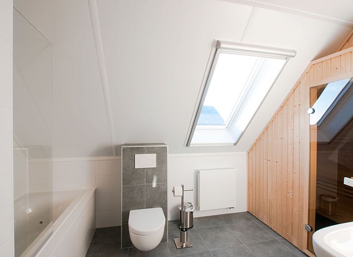 Moderne woonkamer in Vakantiehuis Oesterdam Resort, Tholen, Zeeland, met comfortabele banken en veel natuurlijk licht.