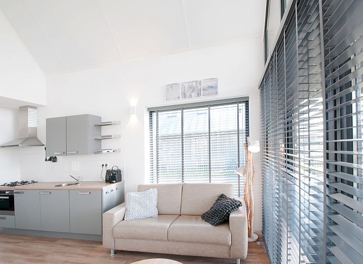 Strand am Ferienhaus Oesterdam Resort in Tholen, Zeeland mit Sonnenuntergang und Liegestuehlen.