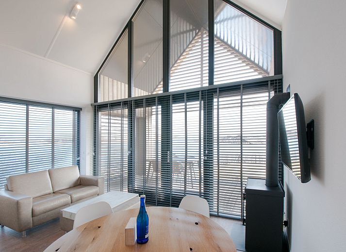 Strand am Ferienhaus Oesterdam Resort in Tholen, Zeeland mit Sonnenuntergang und Liegestuehlen.