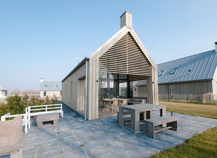 Strand am Ferienhaus Oesterdam Resort in Tholen, Zeeland mit Sonnenuntergang und Liegestuehlen.