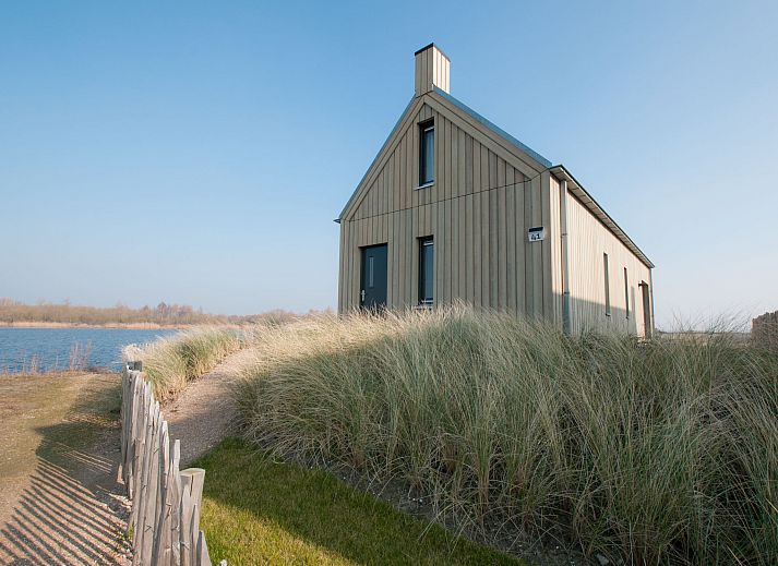 Modernes Interieur des Ferienhauses Oesterdam Resort in Tholen, Zeeland, mit hohen Fenstern.