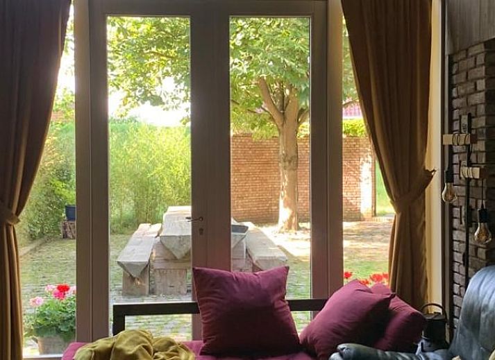 Traditionelle Puppe am Fenster mit Blick auf den Garten, Cottage in Stavenisse, Ferienhaus in Zeeland.