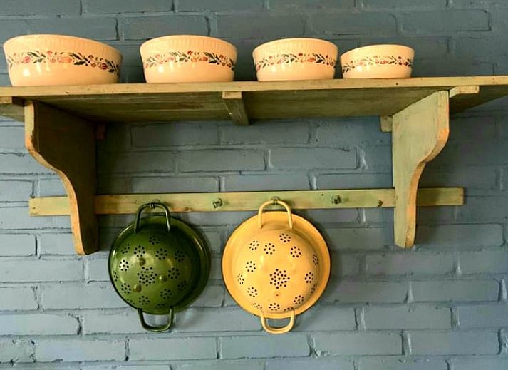 Traditionelle Puppe am Fenster mit Blick auf den Garten, Cottage in Stavenisse, Ferienhaus in Zeeland.