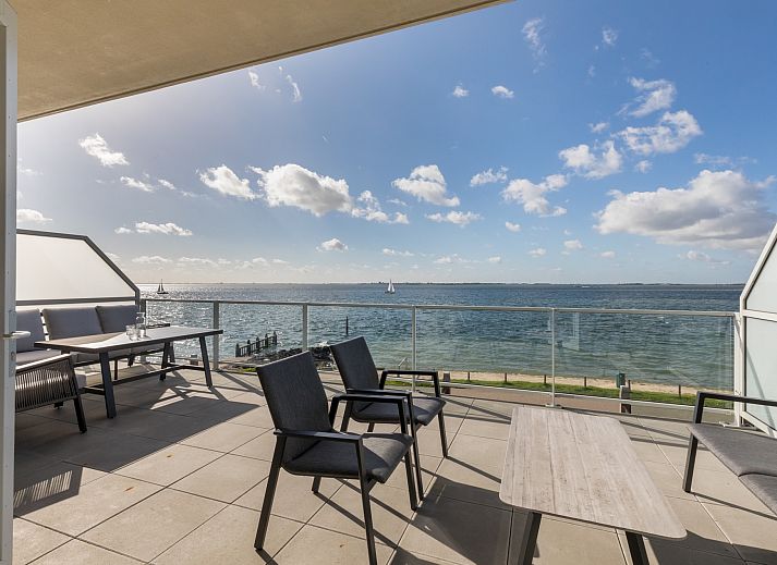 Lichte woonkamer van Appartement in Scherpenisse, Zeeland, met uitzicht op zee vanaf het terras en moderne inrichting voor een ontspannen verblijf.