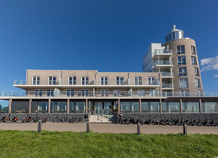 Lichte woonkamer van Appartement in Scherpenisse, Zeeland, met uitzicht op zee vanaf het terras en moderne inrichting voor een ontspannen verblijf.