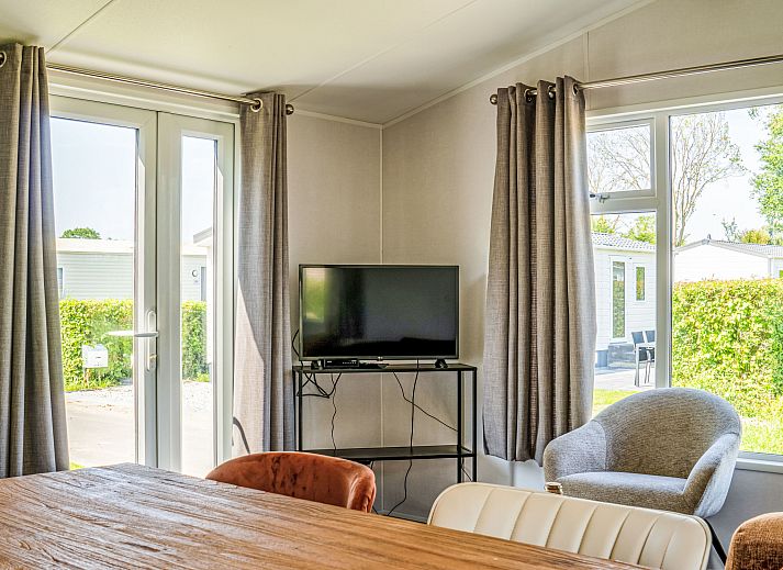 Gemuetliches Wohnzimmer im Ferienhaus Sunset, Scherpenisse, Tholen, mit bequemem Sofa.