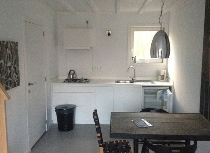 Terrasse im Ferienhaus in Koudekerke, Walcheren, mit Sitzgelegenheit und Blick auf den Garten.