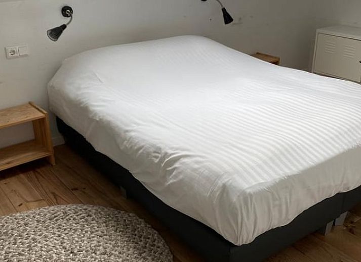 Terrasse im Ferienhaus in Koudekerke, Walcheren, mit Sitzgelegenheit und Blick auf den Garten.