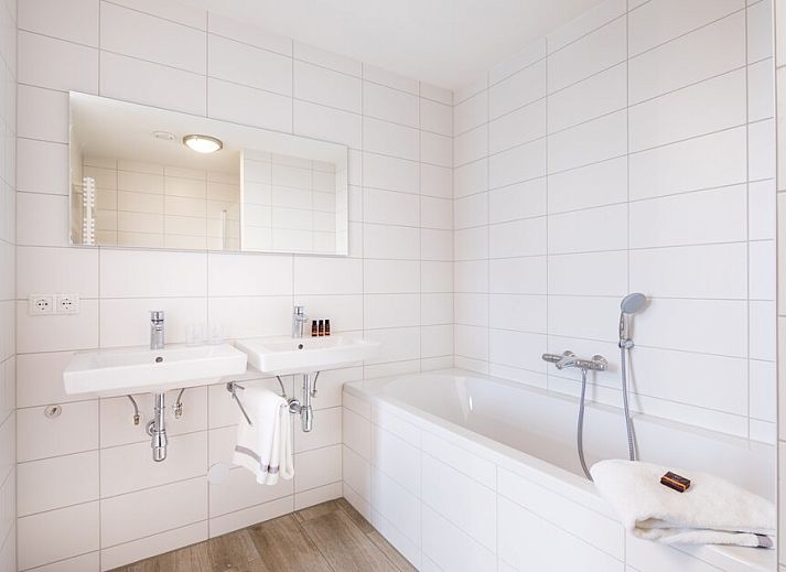 Geraeumiges Wohnzimmer in der Wohnung Van Nes Luxe 4, Koudekerke, Walcheren, Zeeland, mit stilvollem Mobiliar und bequemer Sitzecke.