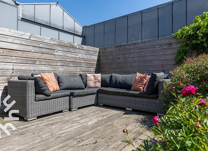 Geraeumige Terrasse des Ferienhauses ZE142 in Koudekerke, Walcheren mit grossem Sonnenschirm und Sitzgelegenheit.