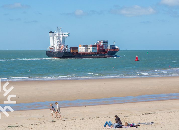 Geraeumige Terrasse des Ferienhauses ZE142 in Koudekerke, Walcheren mit grossem Sonnenschirm und Sitzgelegenheit.
