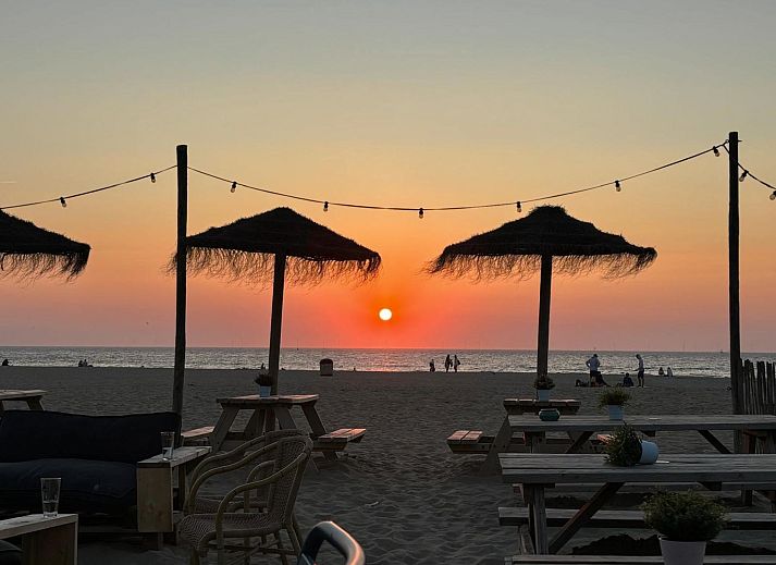 Aussenterrasse des Ferienhauses 'T Bloemenhof Koudekerke mit Holztischen und Stuehlen, Walcheren, Zeeland.