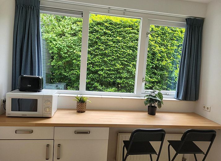 Tuin met eettafel en speeltoestel bij VZ2330 Vakantiehuis in Oostkapelle, Walcheren, Zeeland.