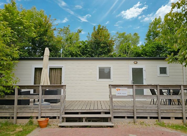 Huisje in Oostkapelle met veranda op Walcheren, Zeeland, omgeven door groene natuur.