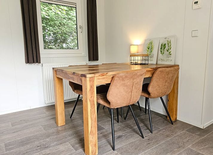 Gezellige binnenruimte van Huisje in Oostkapelle, Walcheren, met eettafel en tv.