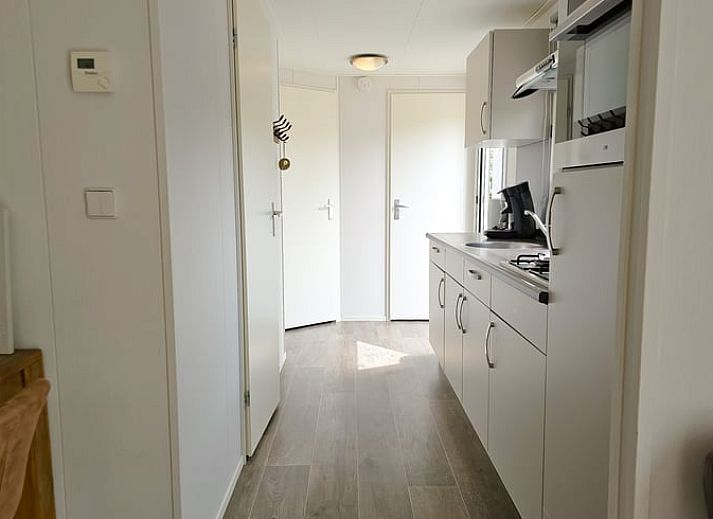 Gezellige binnenruimte van Huisje in Oostkapelle, Walcheren, met eettafel en tv.