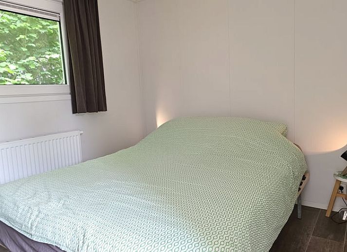 Gezellige binnenruimte van Huisje in Oostkapelle, Walcheren, met eettafel en tv.