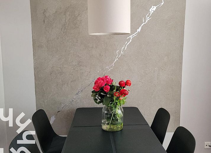 Veranda des Ferienhauses ZE744 in Oostkapelle, Walcheren, Zeeland mit Holztisch und Korbsesseln.