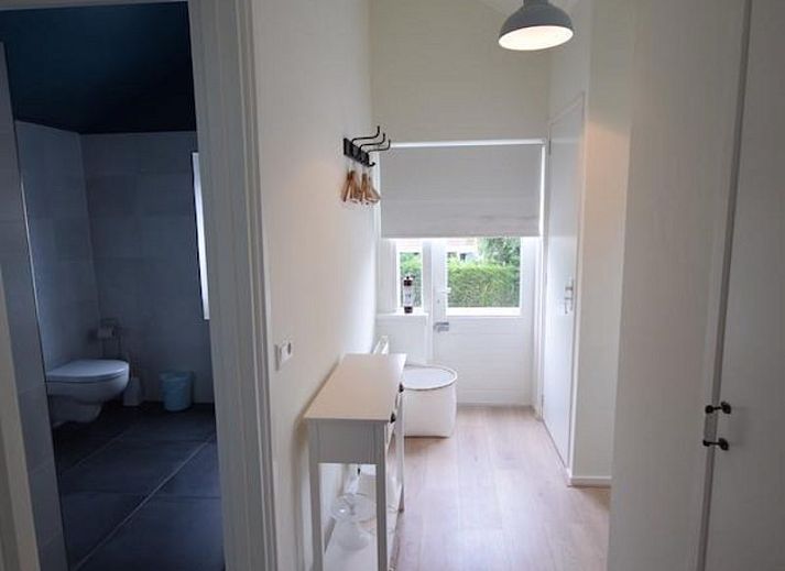 Hoelzerner Picknicktisch im Garten des Ferienhauses VZ1158 in Oostkapelle, Walcheren, umgeben von Gruenflaechen.